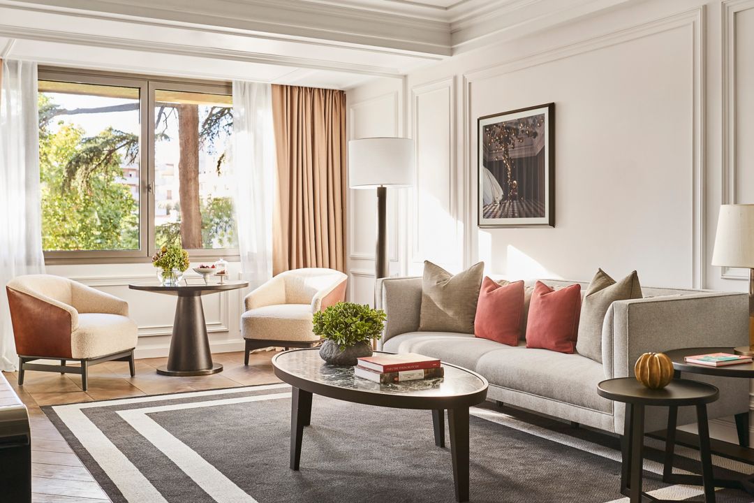 Interior of the Villa Magna Suite bedroom showing a king bed with white sheets and green painted walls at a luxury hotel in Madrid